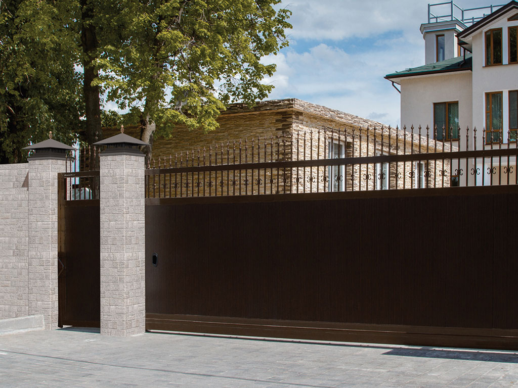 Сдвижные ворота с пиками и вензелями. Цвет полотна — «венге», цвет окантовки — RAL 8014 (коричневый)