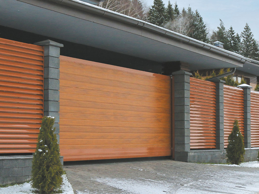 Сдвижные ворота с горизонтальным расположением панелей. Цвет полотна — «золотой дуб», цвет окантовки — RAL 8003 (коричневый, нестандарт)