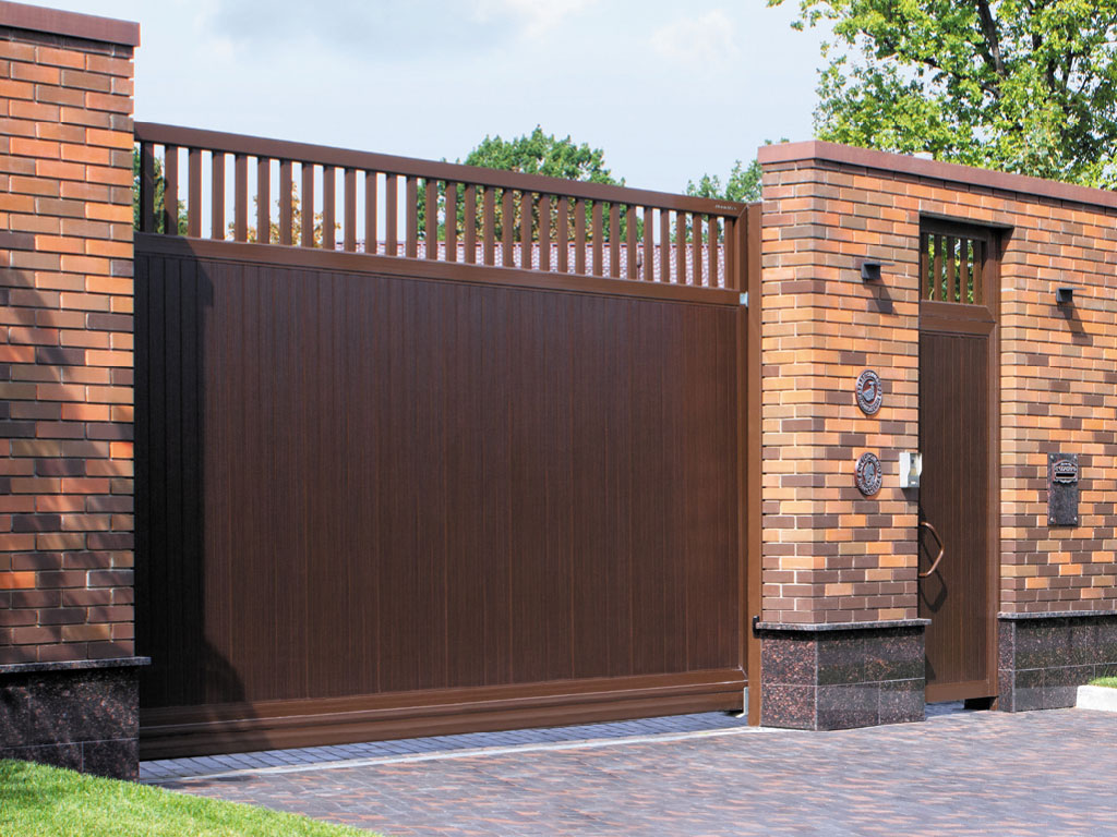 Сдвижные ворота с вертикальным расположением панелей. Цвет полотна — «венге», цвет окантовки — RAL 8014 (коричневый)