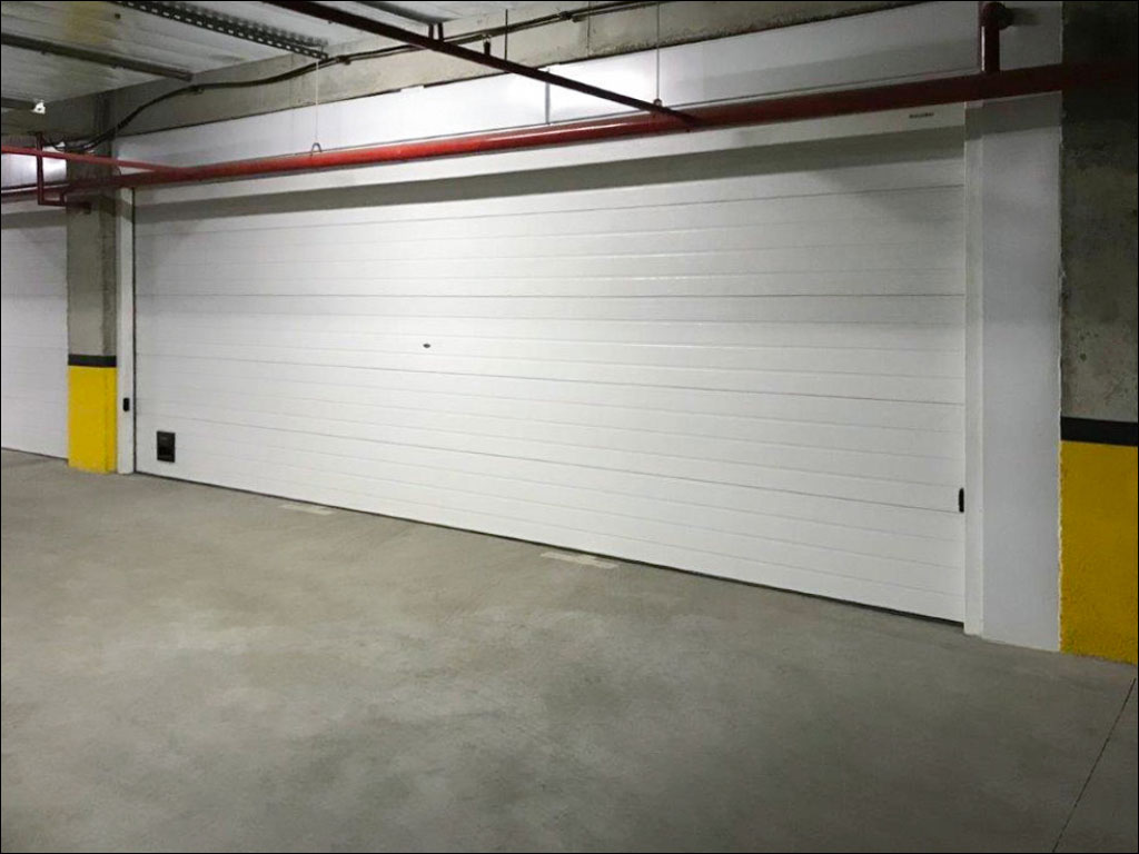 Промышленные секционные ворота ISD03ALU, установленные на подземной парковке в жилом комплексе